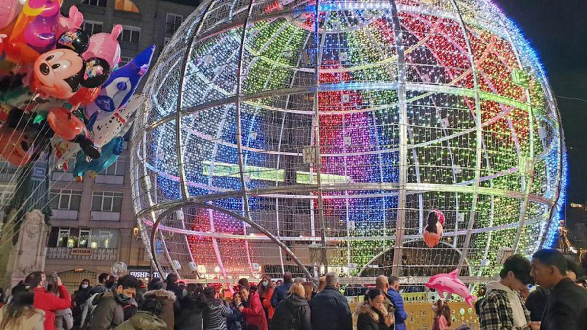 La gran bola de Navidad ya recibió las primeras visitas tras la puesta en marcha de las luces.