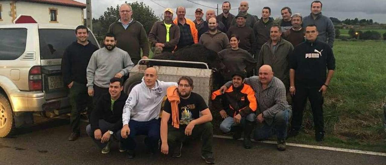 Un grupo de cazadores de Gozón posa con el jabalí abatido, sobre el carro.