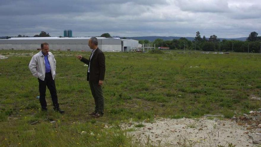 El alcalde de Curtis, dcha., y el teniente de alcalde, en la parcela en la que se preveía la planta de Renova. l. o.