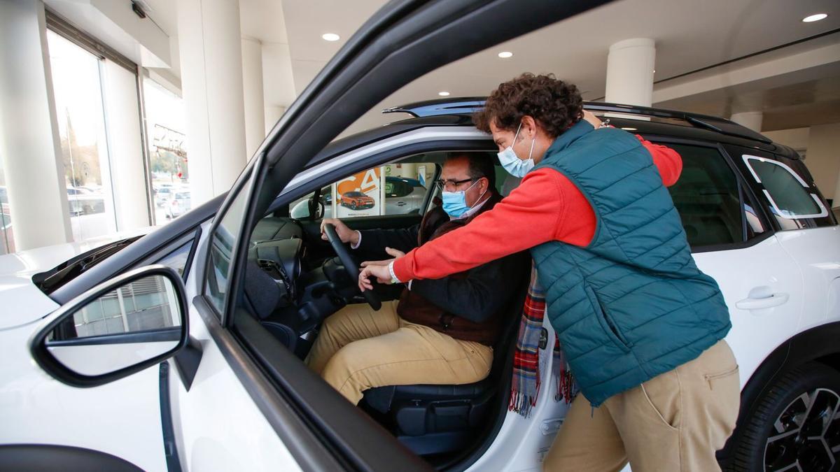 Dos hombres prueban un vehículo nuevo en un concesionario de la ciudad.