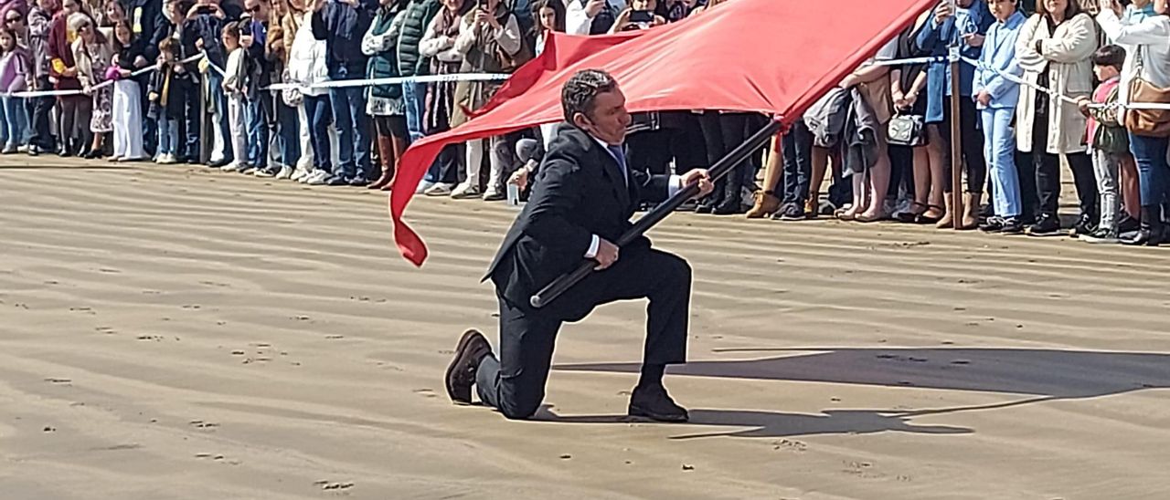 César Menéndez ondea la bandera sin que roce la arena.