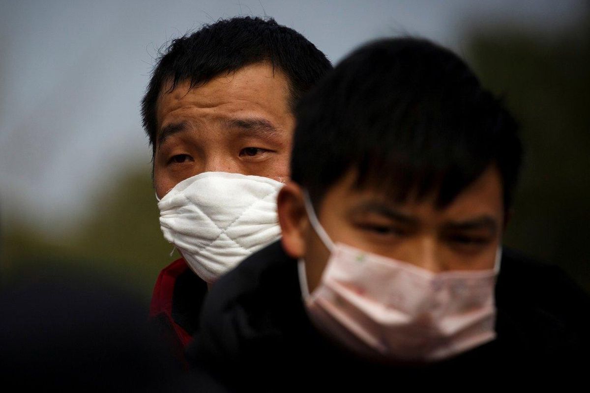 FILE PHOTO: People coming from the Hubei province wait at a checkpoint at the Jiujiang Yangtze River Bridge in Jiujiang, Jiangxi province, China, as the country is hit by an outbreak of a new coronavirus, February 1, 2020.  REUTERS/Thomas Peter - RC2JRE950YUT/File Photo