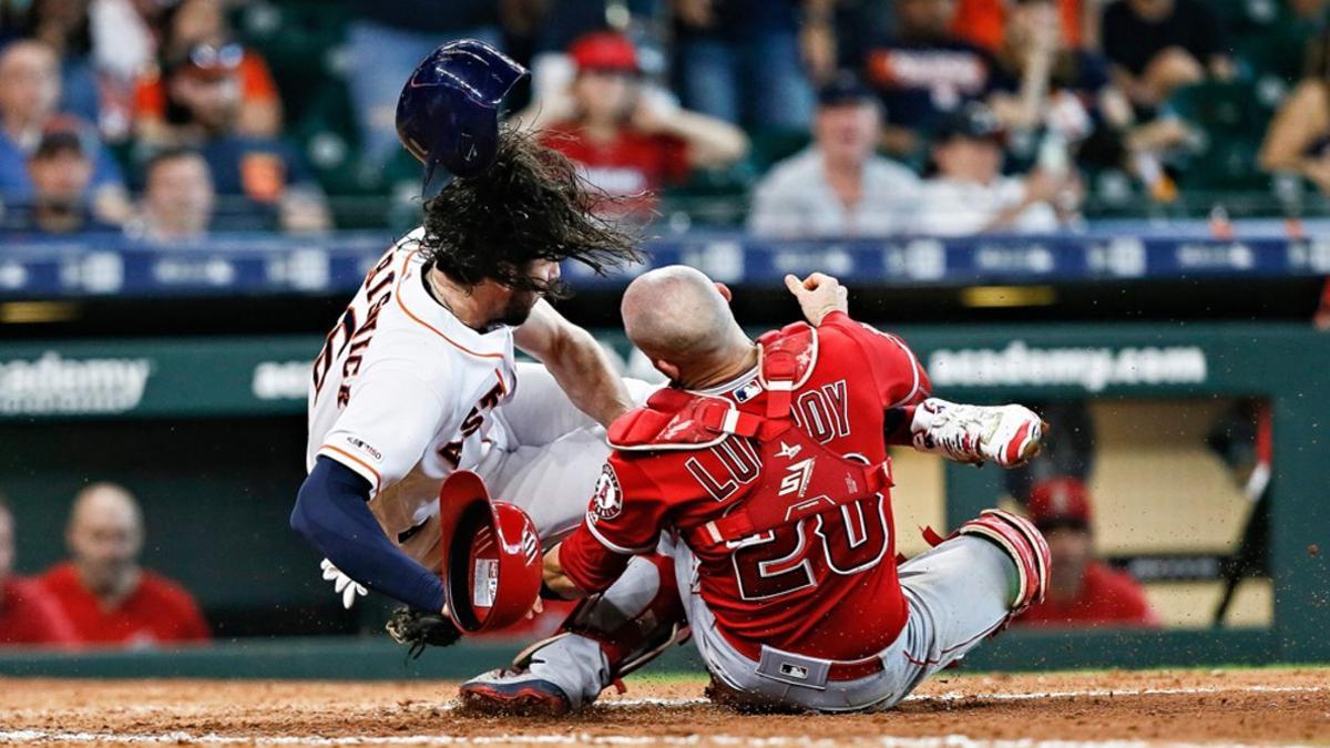 Jake Marisnick de los Houston Astros choca con el receptor Jonathan Lucroy de Los Angeles Angels.