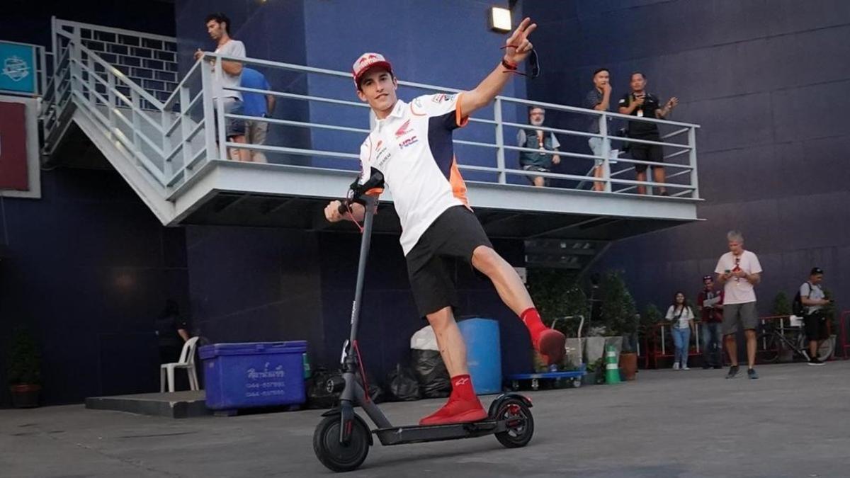 Marc Márquez sale, alegremente, de la sala de prensa del circuito de Buriram (Tailandia), montado en su patinete.