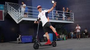 Marc Márquez sale, alegremente, de la sala de prensa del circuito de Buriram (Tailandia), montado en su patinete.