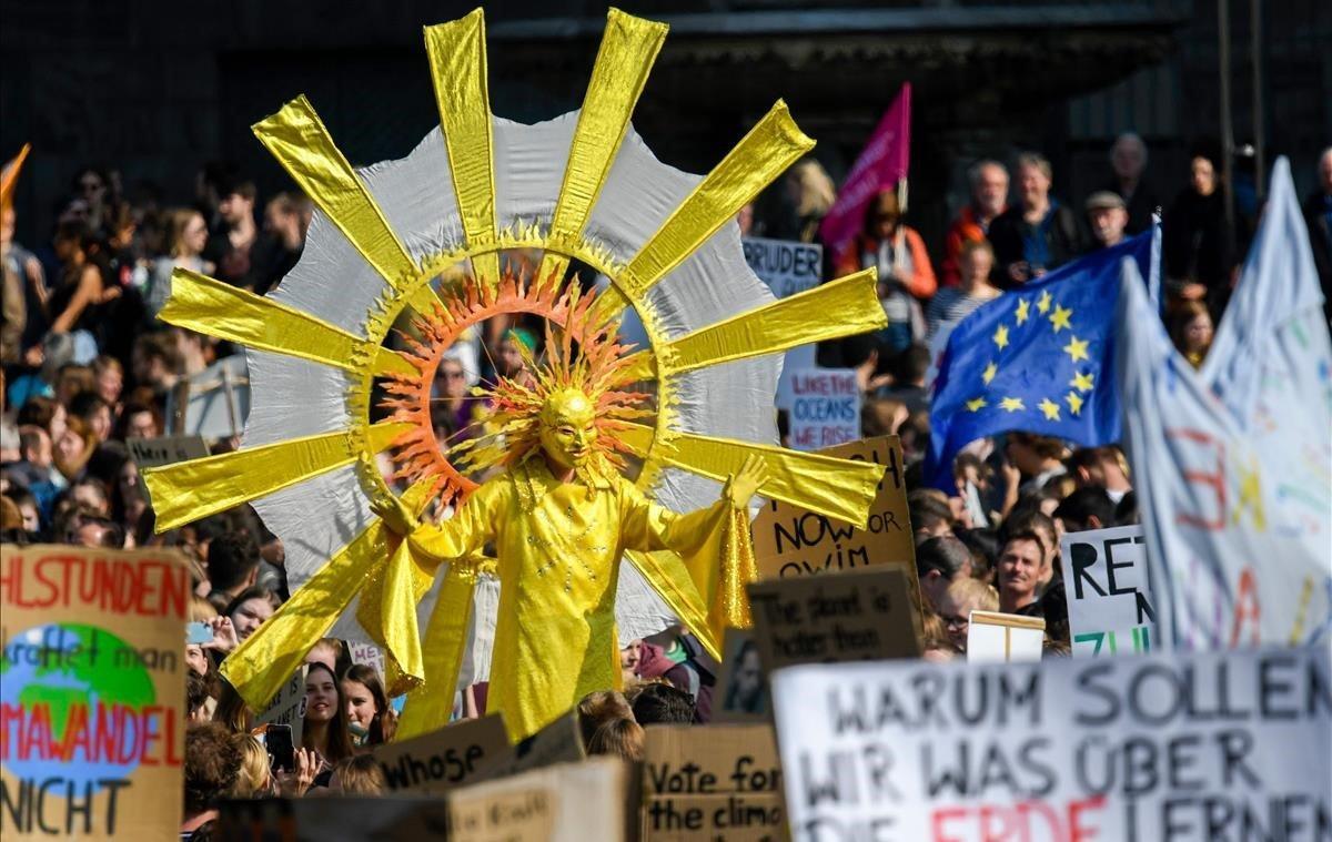 Jóvenes activistas por el clima protestan, con uno de ellos disfrazado de sol, durante una manifestación semanal de los viernes por el futuro, para una mejor política climática en Colonia, Alemania Occidental.