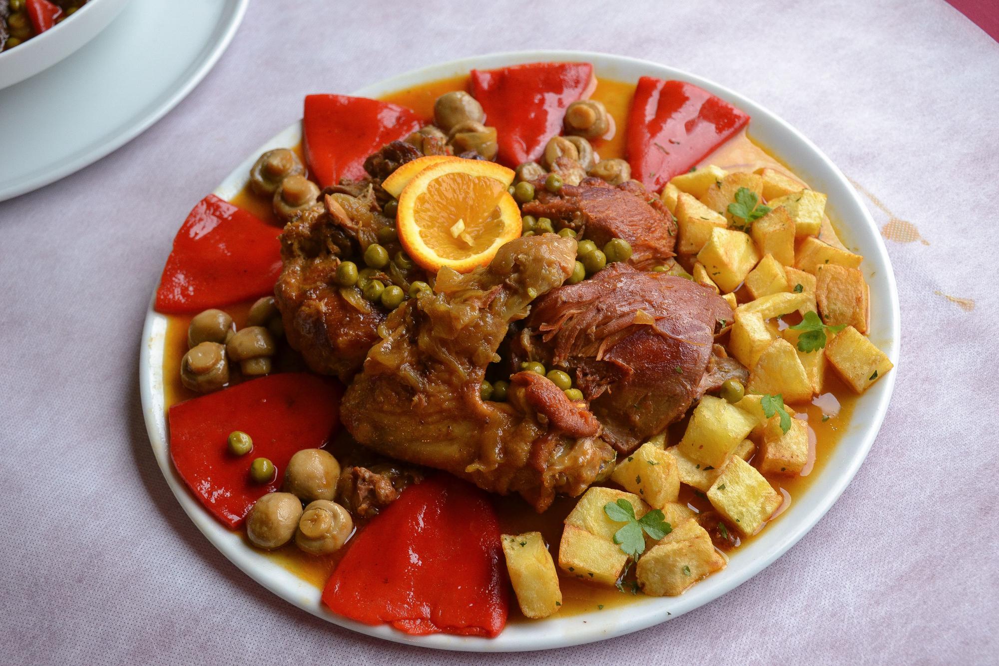 Pitu caleya guisado acompañado de pimientos, guisantes y patatas.