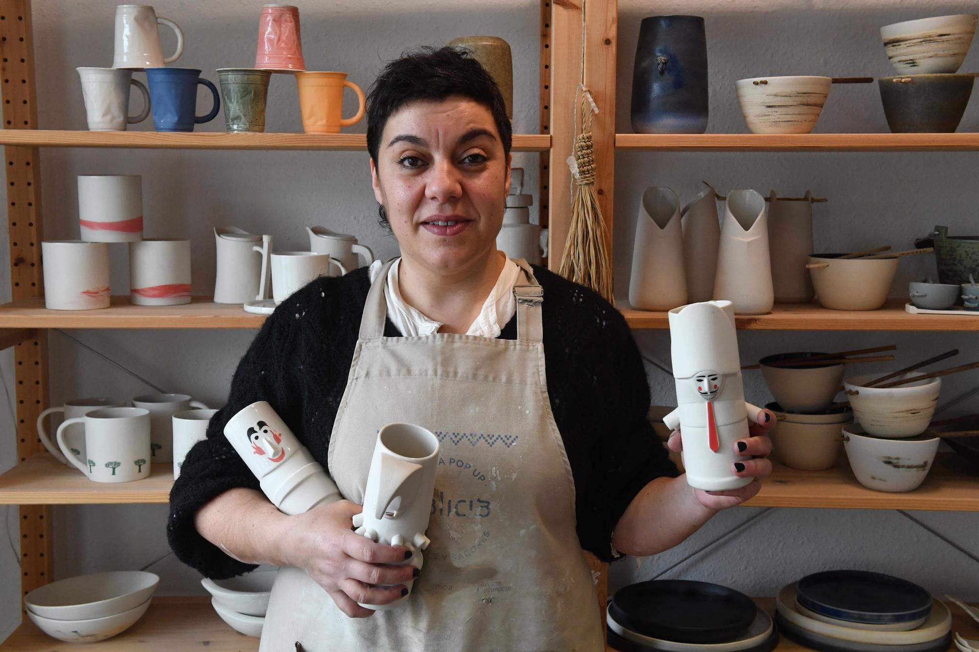 Laura Delgado con los vasos tiki ganadores, una combinación de culturas entre Polinesia y Galicia, y otras obras realizadas por esta ceramista en su taller de Cambre, en el que también da clases a pequeños grupos.