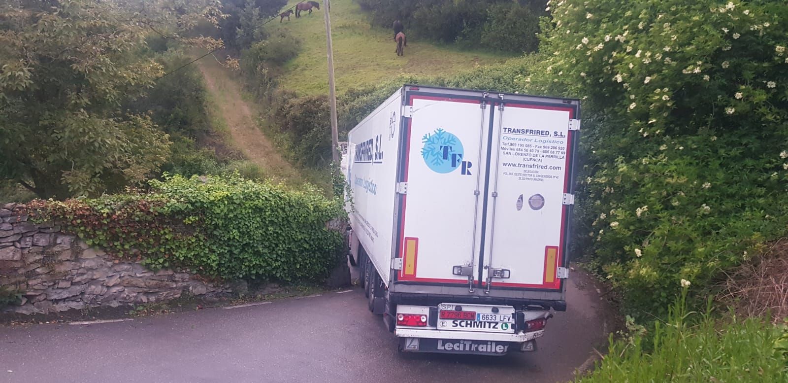 Un camión frigorífico se atasca en un camino rural de Gijón
