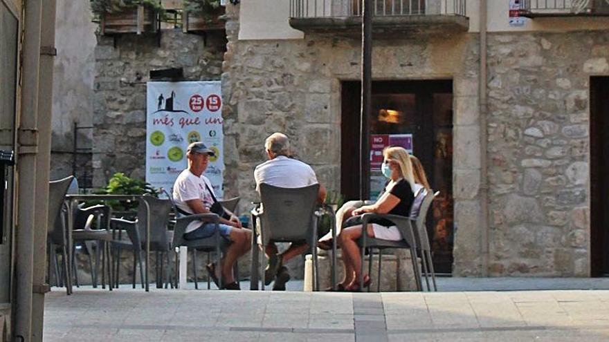 Visitants asseguts a la plaça de Maçanet | SANTI COLL