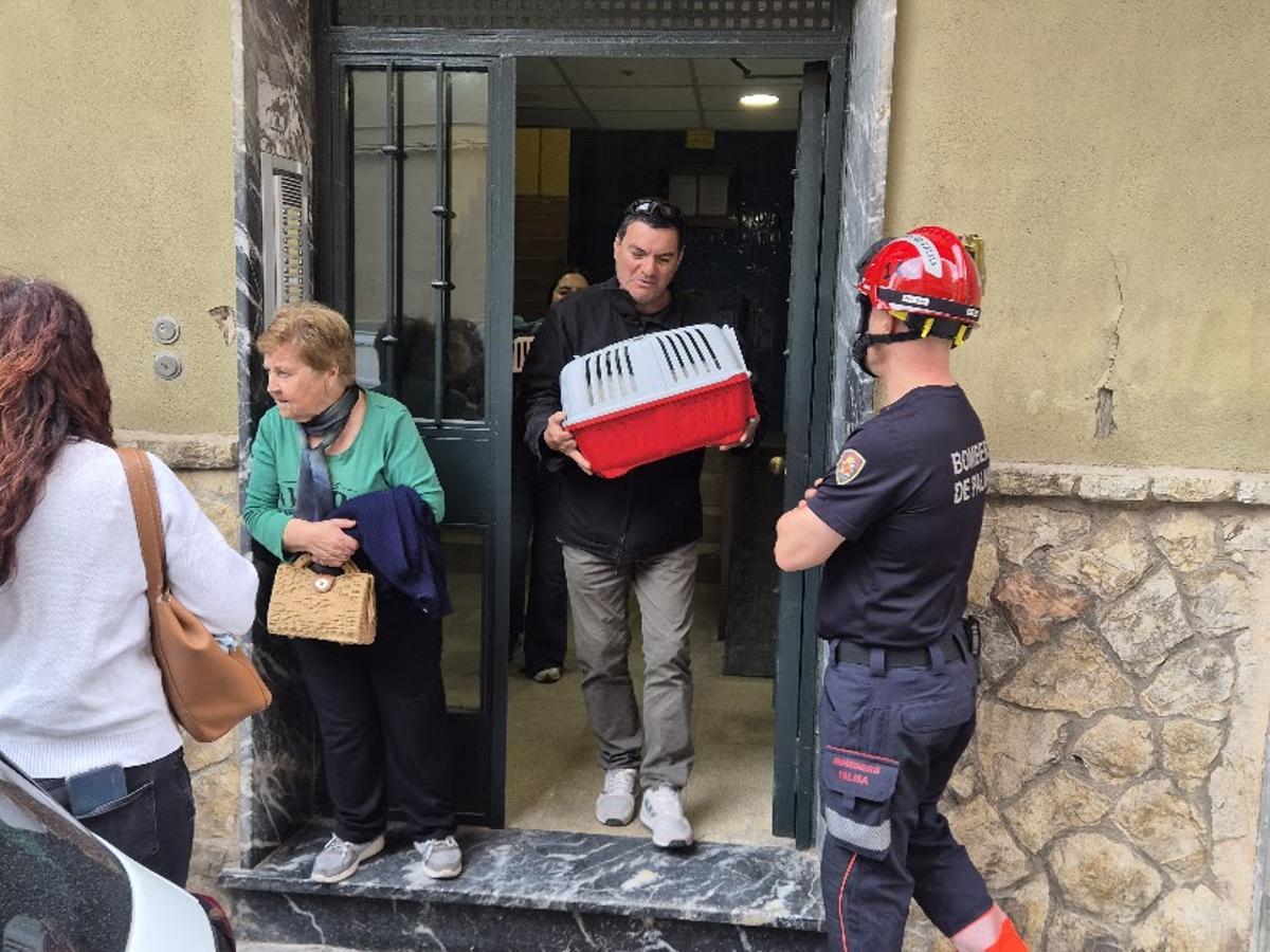 Un vecino sale del número del número 17 de la calle Sant Novici tras recoger a su gato de su casa.