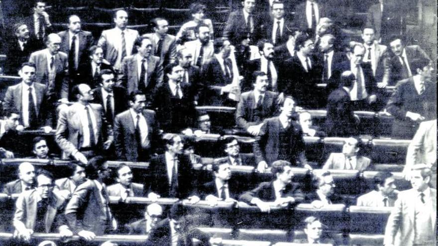 Los diputados se levantan de sus escaños y miran hacia la puerta por la que irrumpe Antonio Tejero | | MANUEL HERNÁNDEZ DE LEÓN