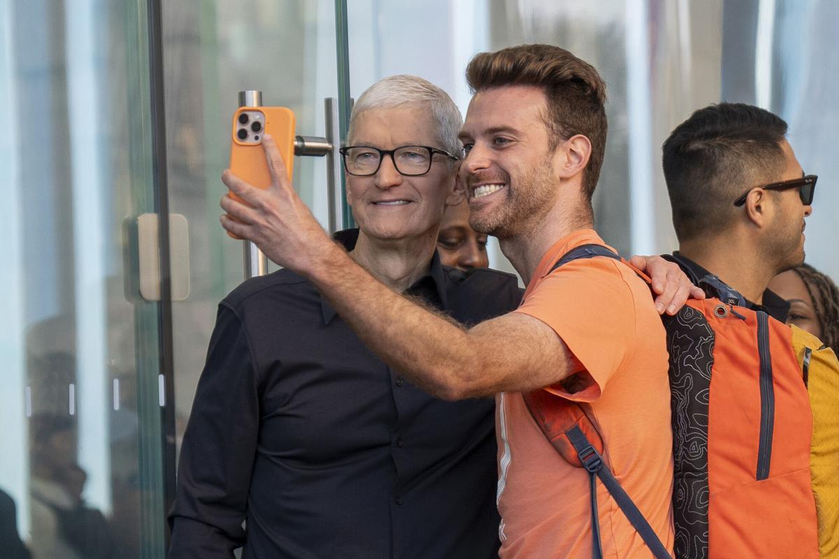 Imagen de archivo del director ejecutivo de Apple, Tim Cook, posando para una foto con un cliente en Nueva York.