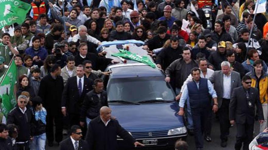 Multitud de personas se agolpan alrededor del coche de Kirchner.
