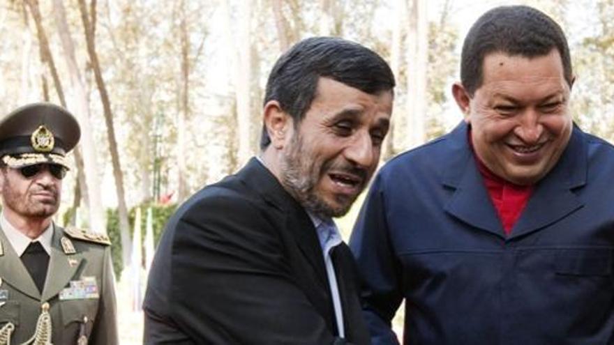 Un oficial iraní observa el saludo entre Ahmadineyad y Chávez.