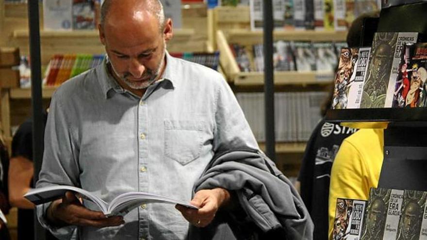 Un visitant del Saló del Còmic llegint un àlbum, ahir