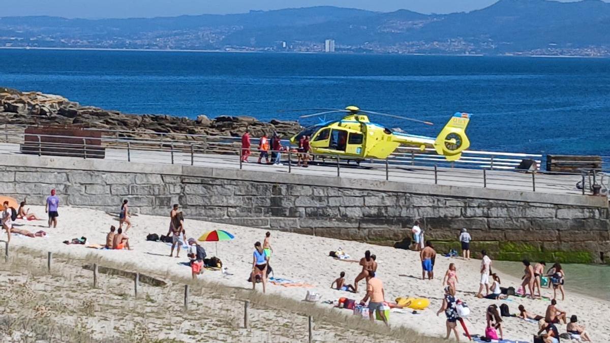Momento en el que el helicóptero de urgencias sanitarias recogía al hombre evacuado en la explanada del muelle de Rodas.