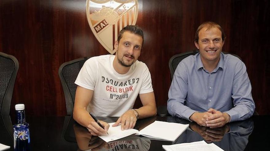 Kuzmanovic, firmando su contrato con Arnau.