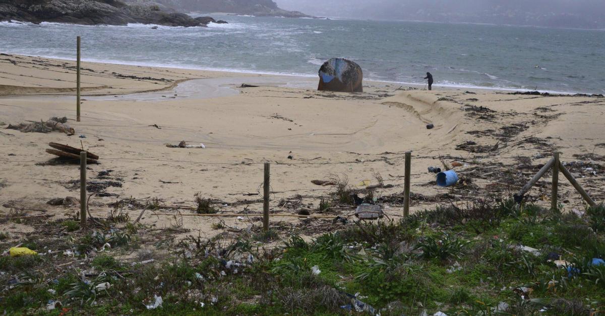Un flotador de batea en la playa de Area de Bon, llena de basura arrastrada por el mar.