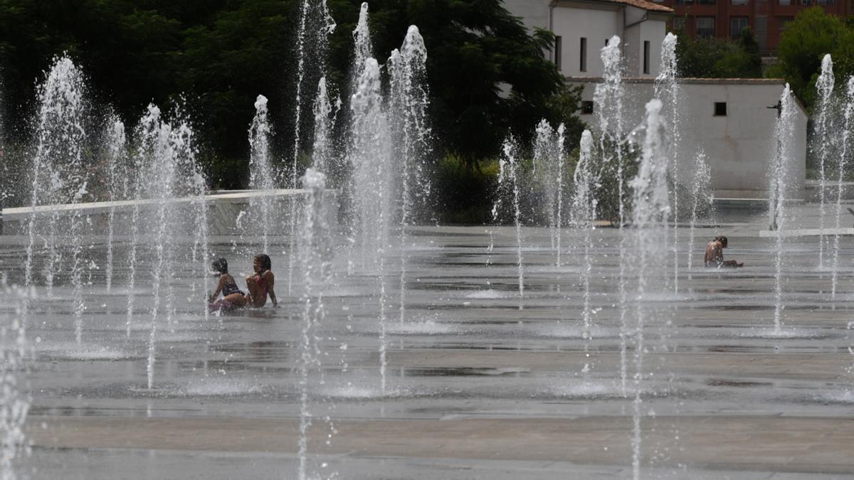 Archivo - Varios niños se refrescan en una fuente del Parc Central,