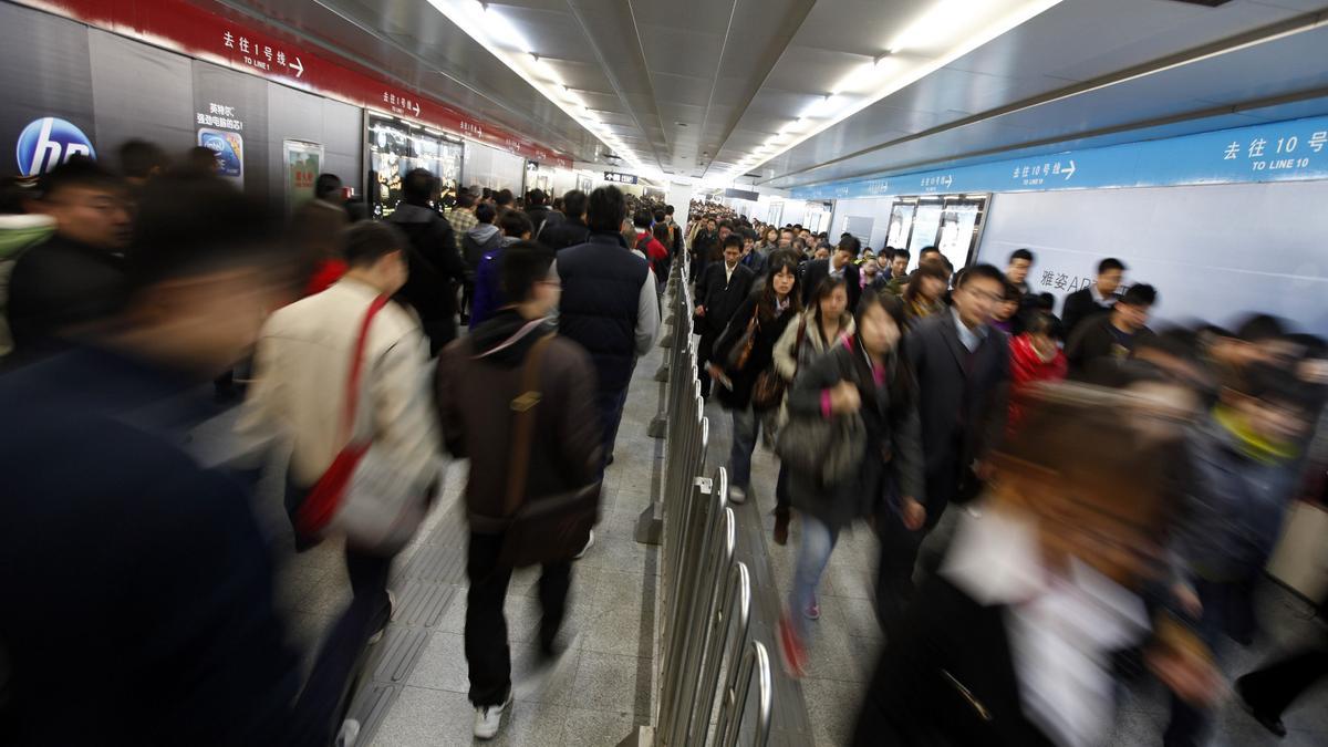 Gente en un túnel en el metro de Pekín