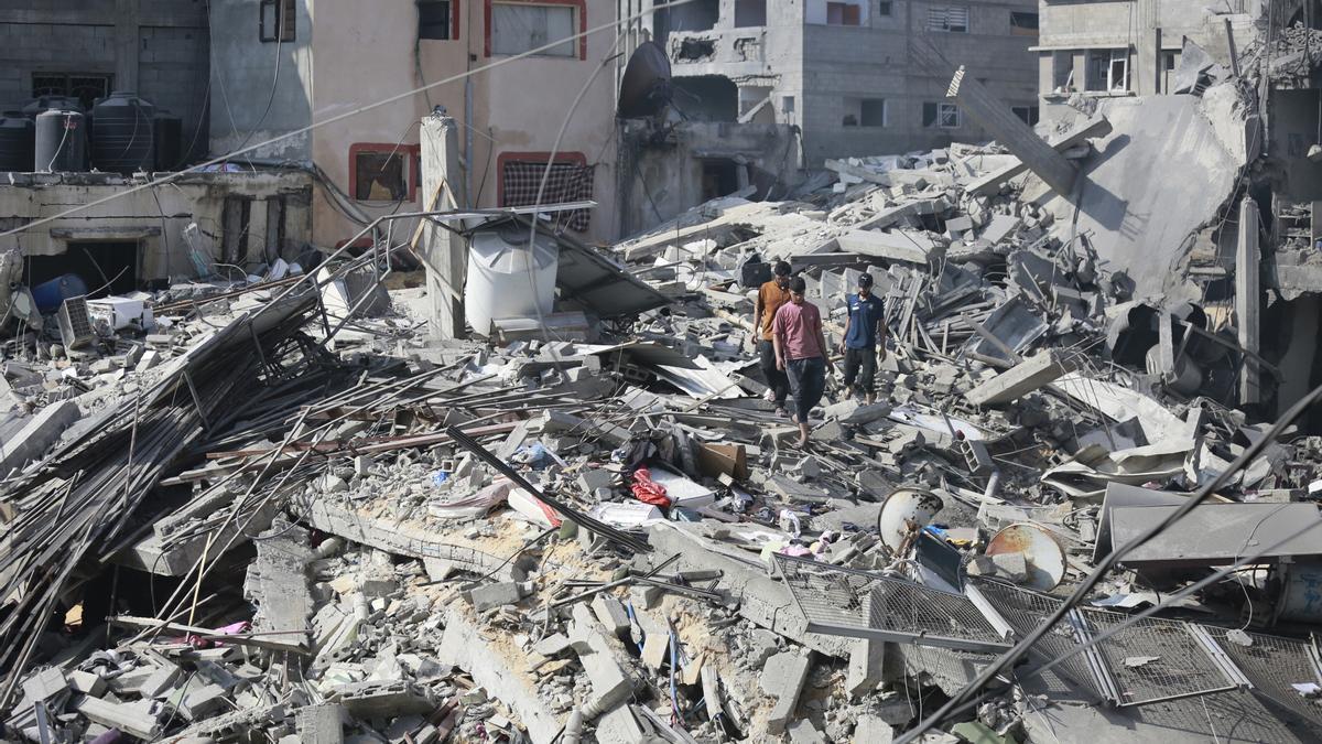 Un grupo de palestinos intenta recuperar sus pertencias entre los escombros de edificios destruidos por los bombardeos de Israel contra el campamento de refugiados de Al Shati, en la ciudad de Gaza (archivo)