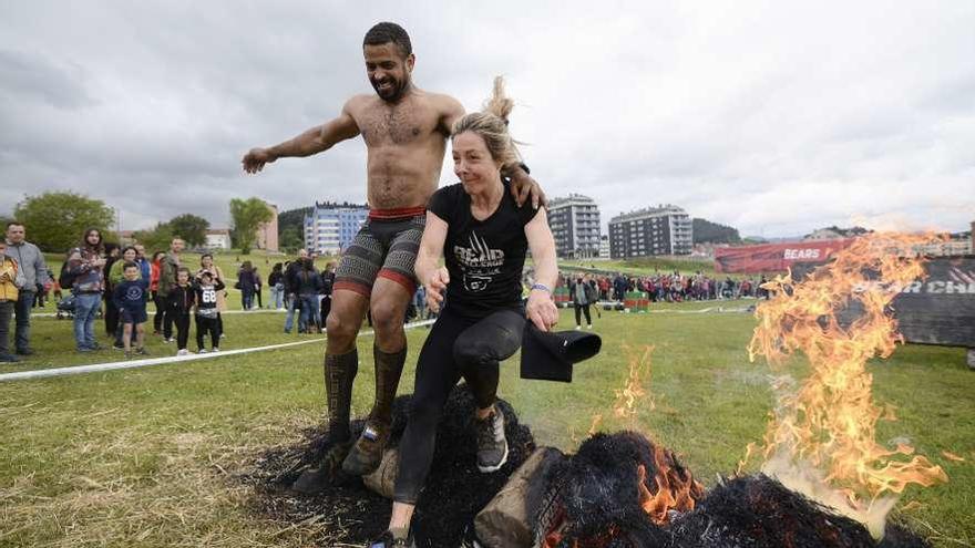 Dos participantes en la carrera saltan uno de los obstáculos de la prueba.