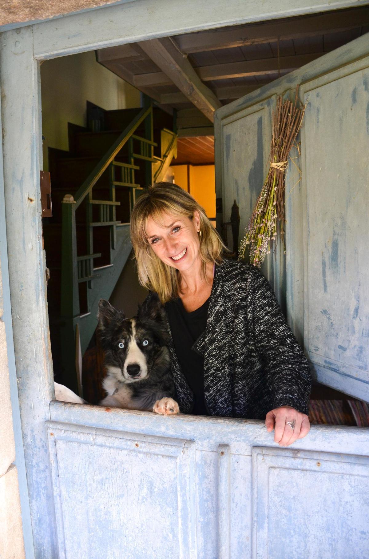 Amaia y su inseprable perro Klaus, asomados a la puerta de cuarterón de su casa de Santa María de Villandás.