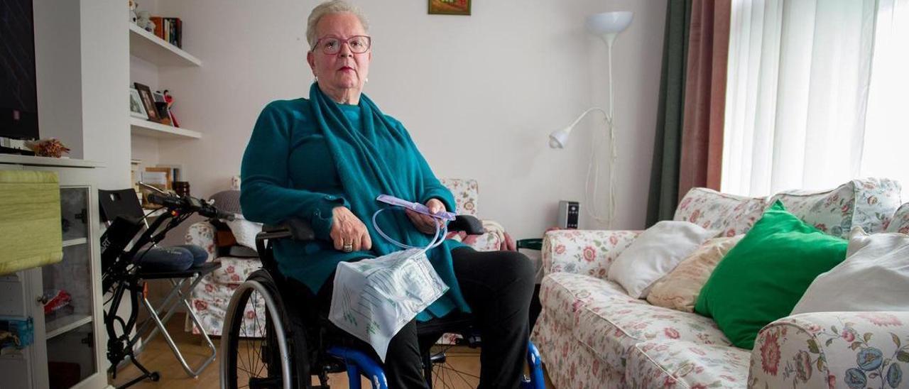 Isabel Castro Díaz, coruñesa con paraplejia tras sufrir un infarto medular, posa con una sonda y una bolsa de recogida de orina, en su casa de Os Mallos.