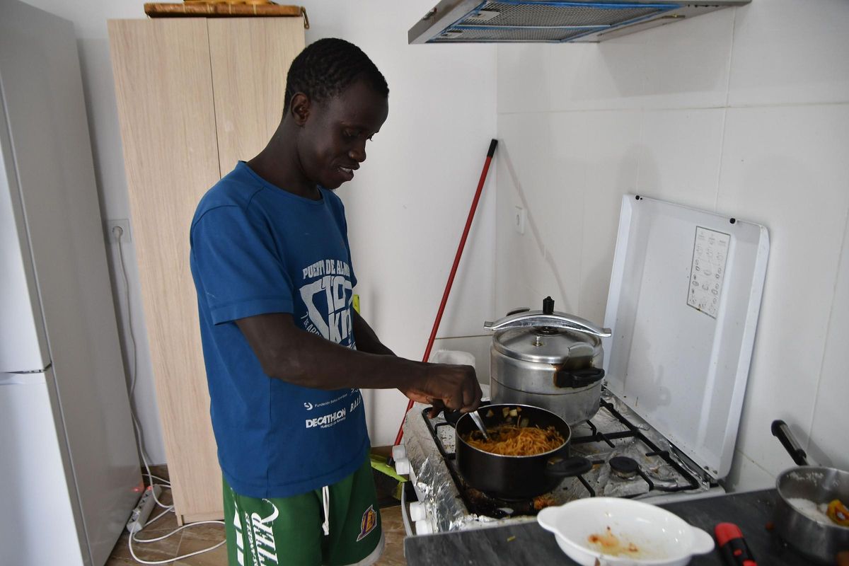 Lamine prepara su comida en una de las viviendas del SMJ en Níjar.