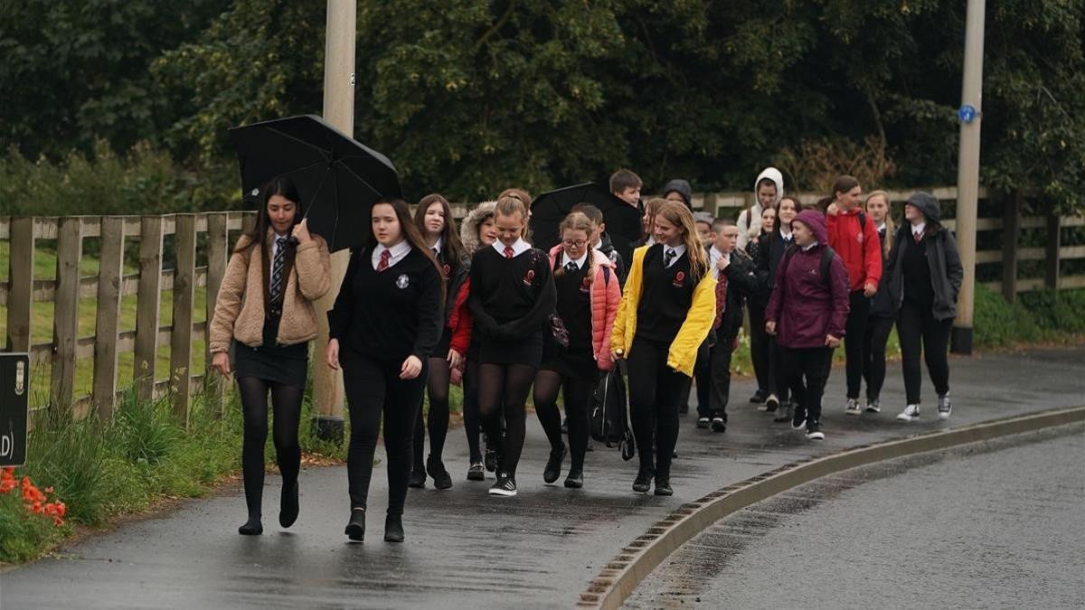 Un grupo de estudiantes escoceses llegan a su escuela, este martes, en su primer día de colegio tras los cinco meses de parón por la pandemia.