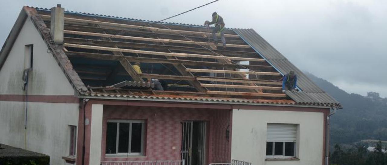 Operarios realizando ayer la reparación del tejado de la vivienda afectada.