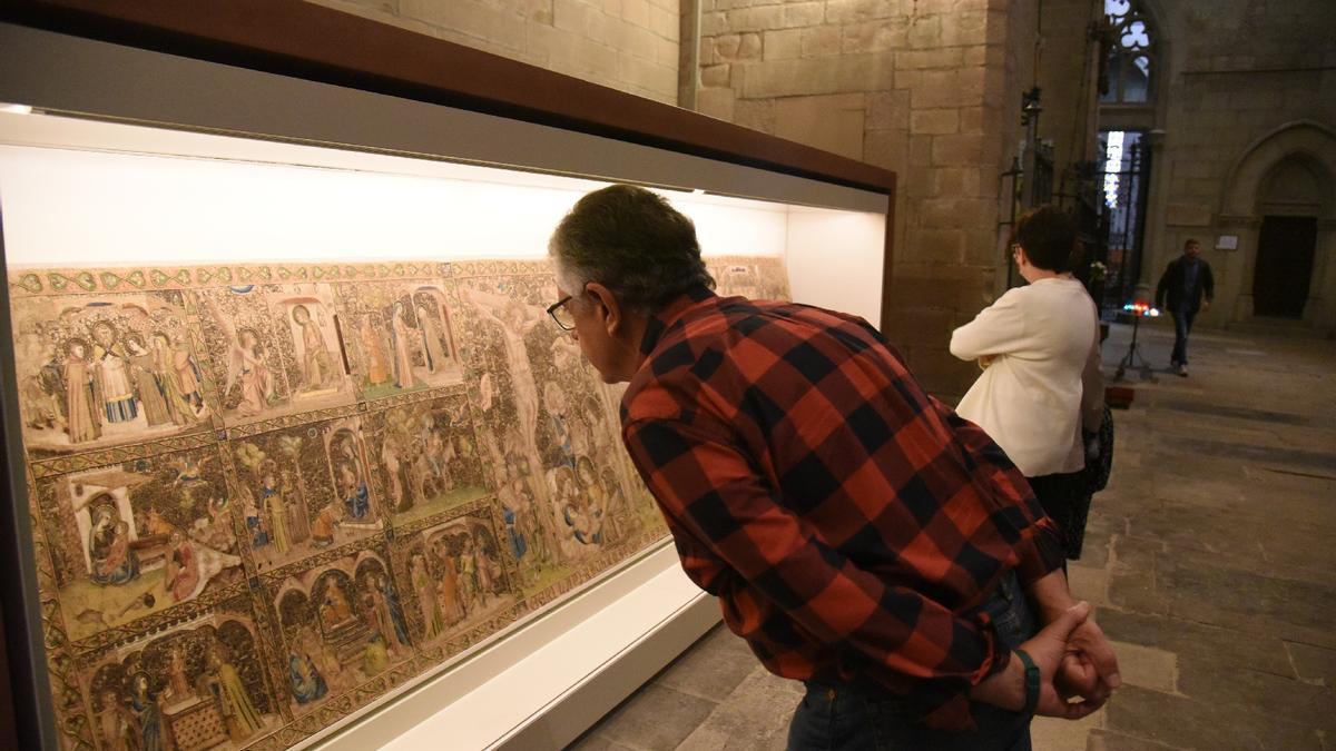 Dues persones admirant el frontal un cop retornat i exposat a la la basílica de la Seu