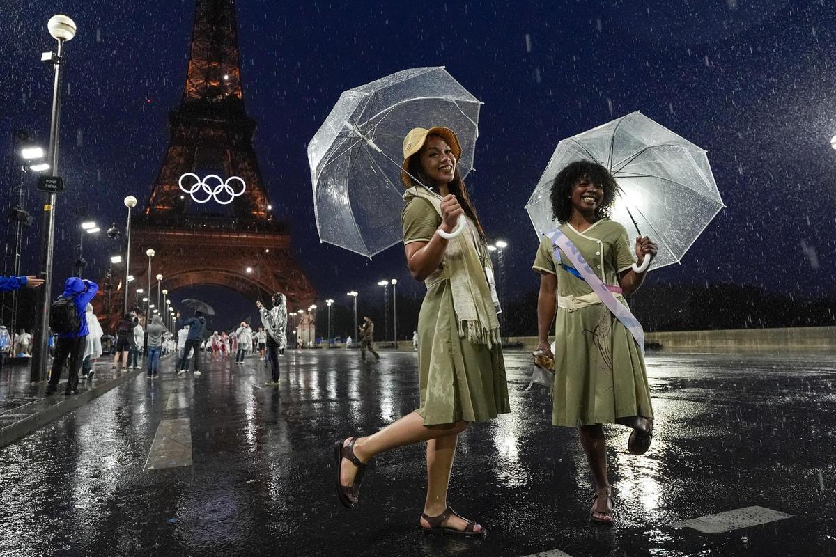 Las atletas de Madagascar sostienen sus paraguas junto a la torre Eiffel durante la ceremonia de apertura de los Juegos Olímpicos de Verano de 2024