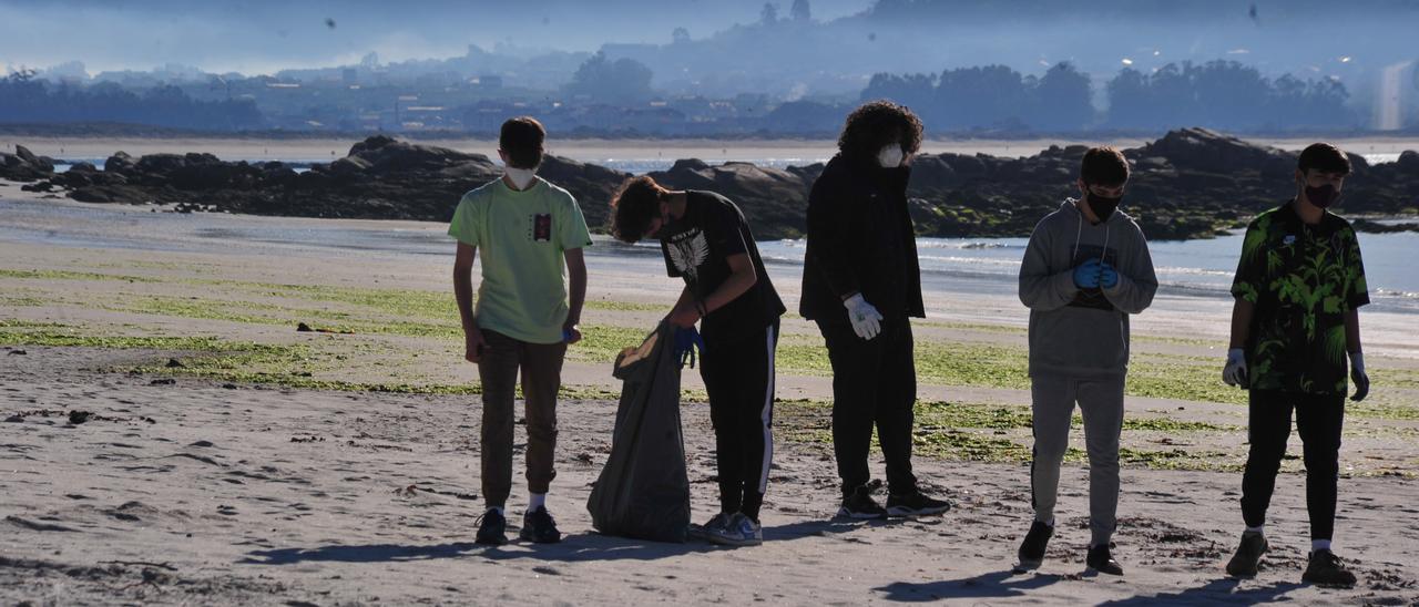 Jóvenes de O Grove en una campaña de eliminación de basura en la playa de Area da Cruz.