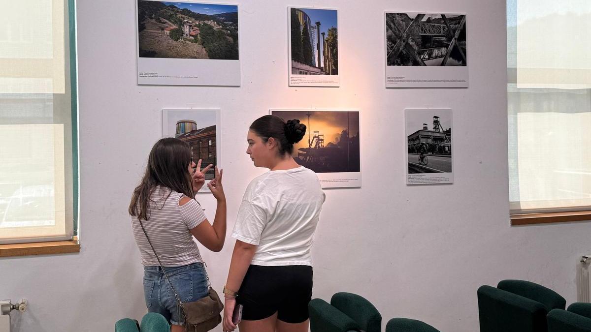 Paula Díaz y Lola Melendi admirando las fotografías de la exposición.