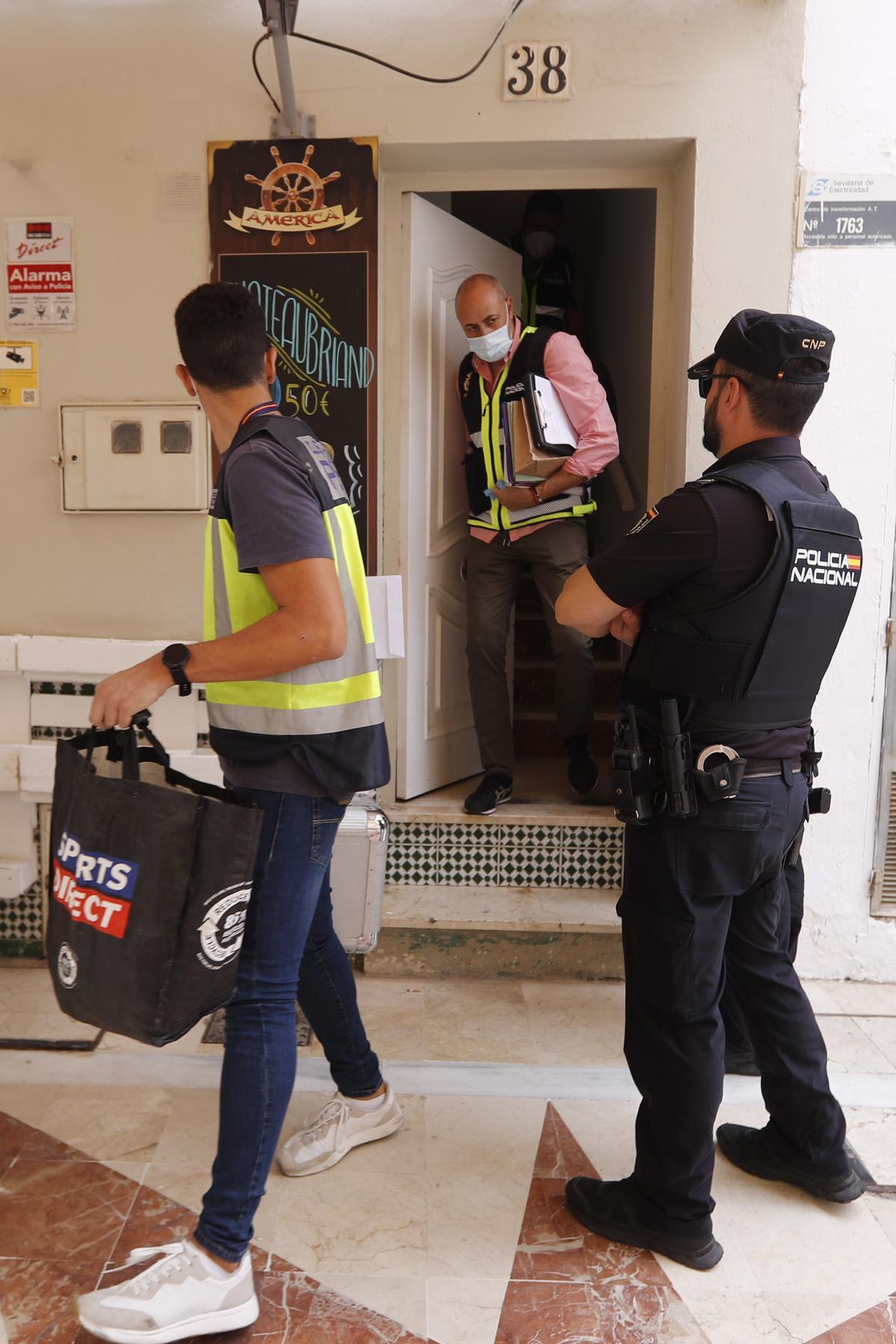 Investigadores salen de la vivienda.