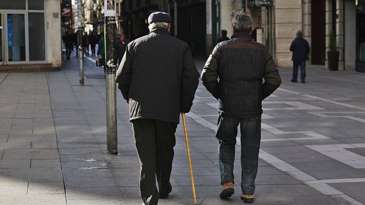 Dos pensionistas pasean por una calle de Zamora