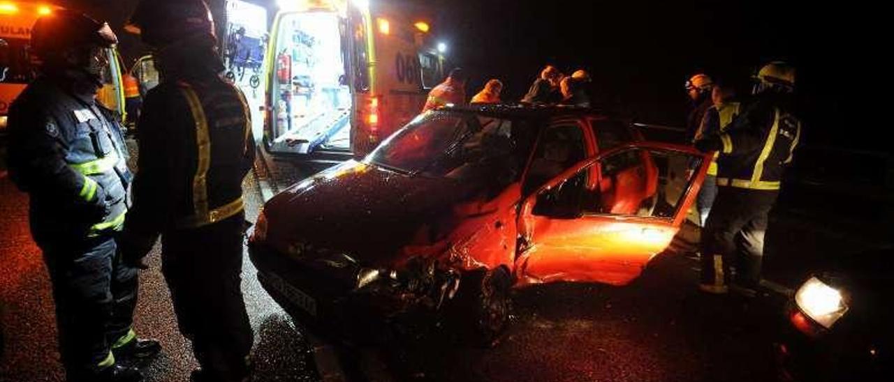 Resguardan de la lluvia con un paraguas al herido del Opel. // I.A.