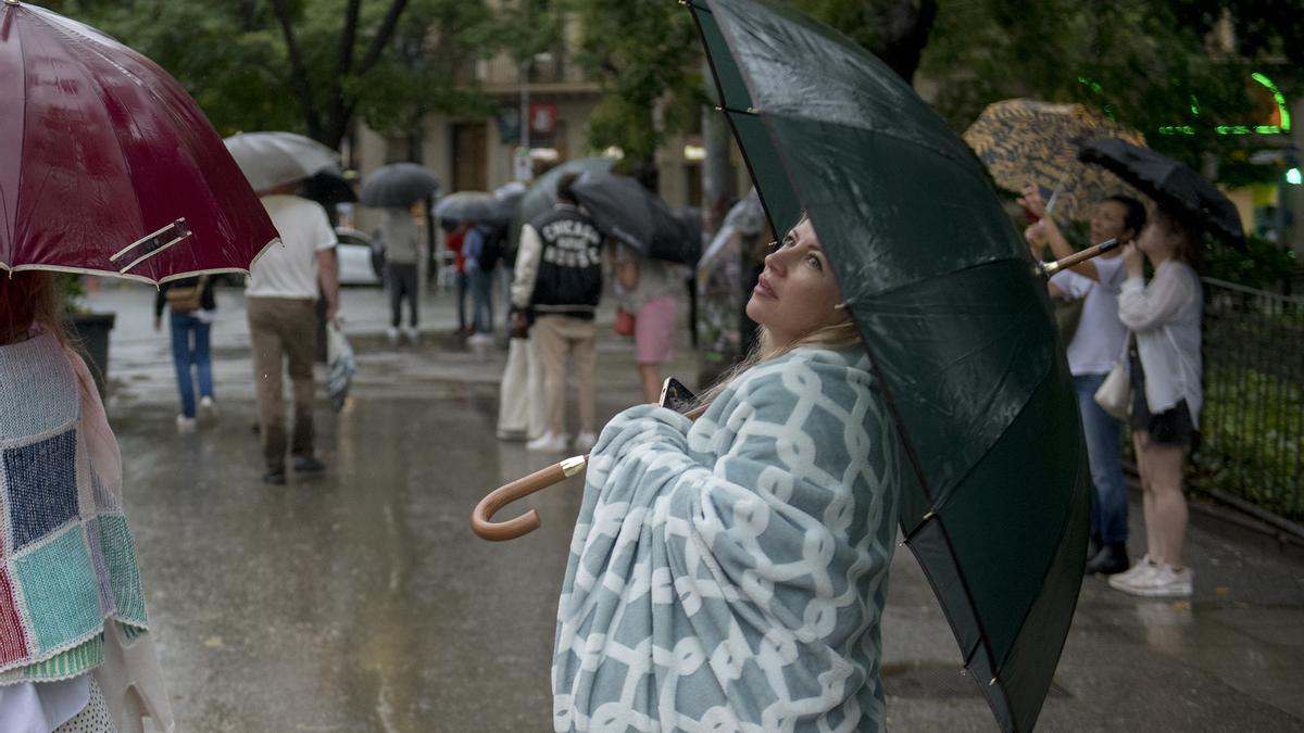 Barcelona. 27.08.2023. Barcelona. Turistas en los alrededores de la Sagrada Familia abrigados y protegidos con sus paraguas de la lluvia, el día que ha descendido la temperatura tras una semana de ola de calor. ( mal tiempo, paraguas, frío). Fotografía de Jordi Cotrina