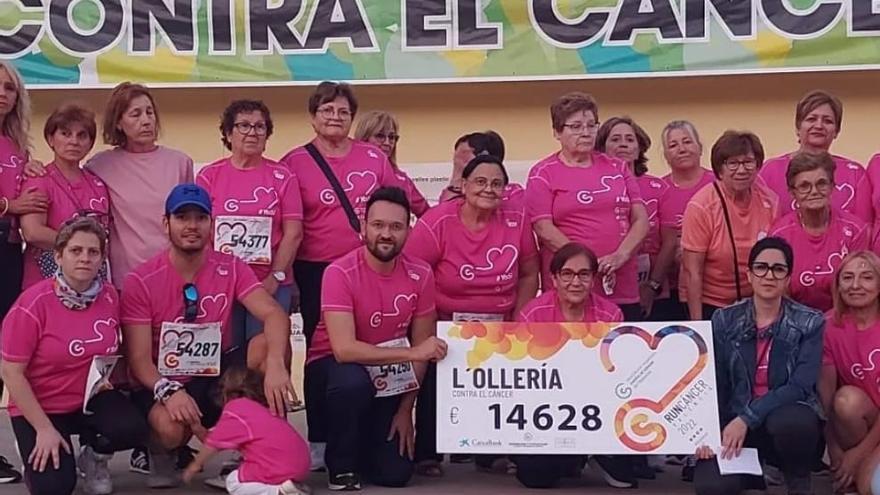 Participantes en la Run Cáncer de l&#039;Olleria muestran el cheque con la recaudación.