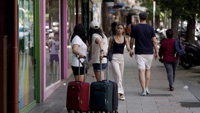 Dos joves amb maletes al barri de Tetuan, un dels districtes més humils de Madrid que s’ha convertit en el segon amb més pisos turístics.