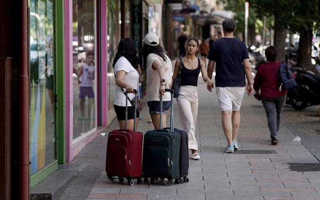 Dos jóvenes con maletas en el barrio de Tetuán, en Madrid.