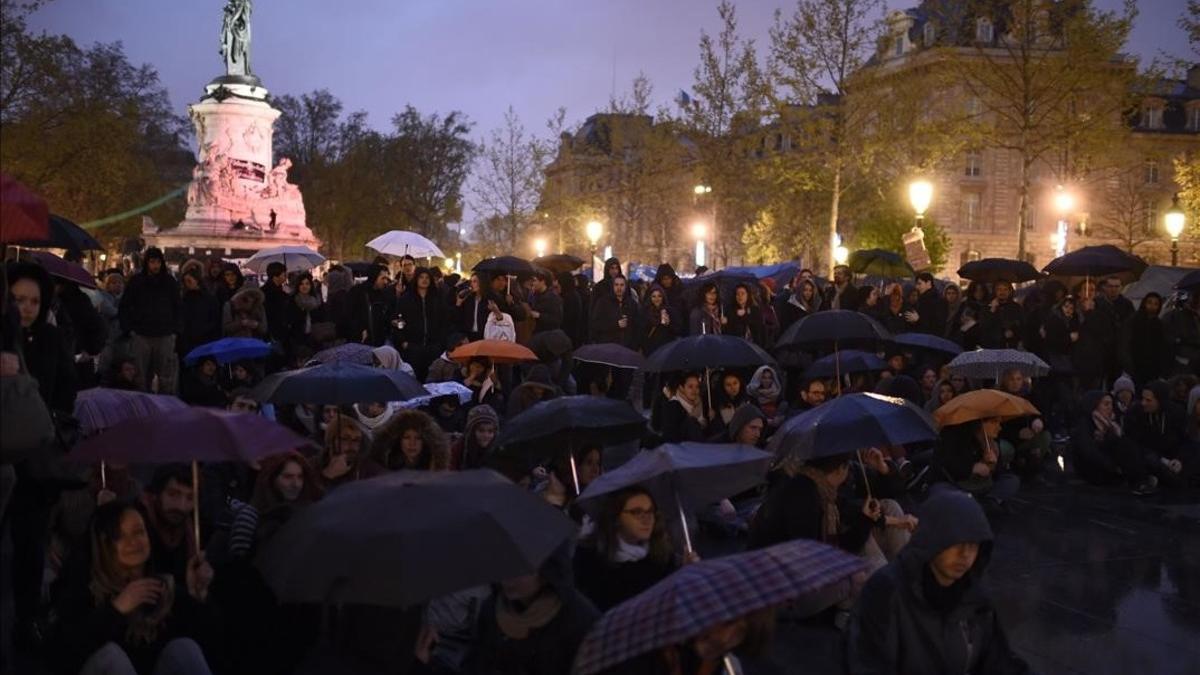 Simpatizantes del movimiento de los indignados franceses se concentran una noche lluviosa en la plaza de la República de París.