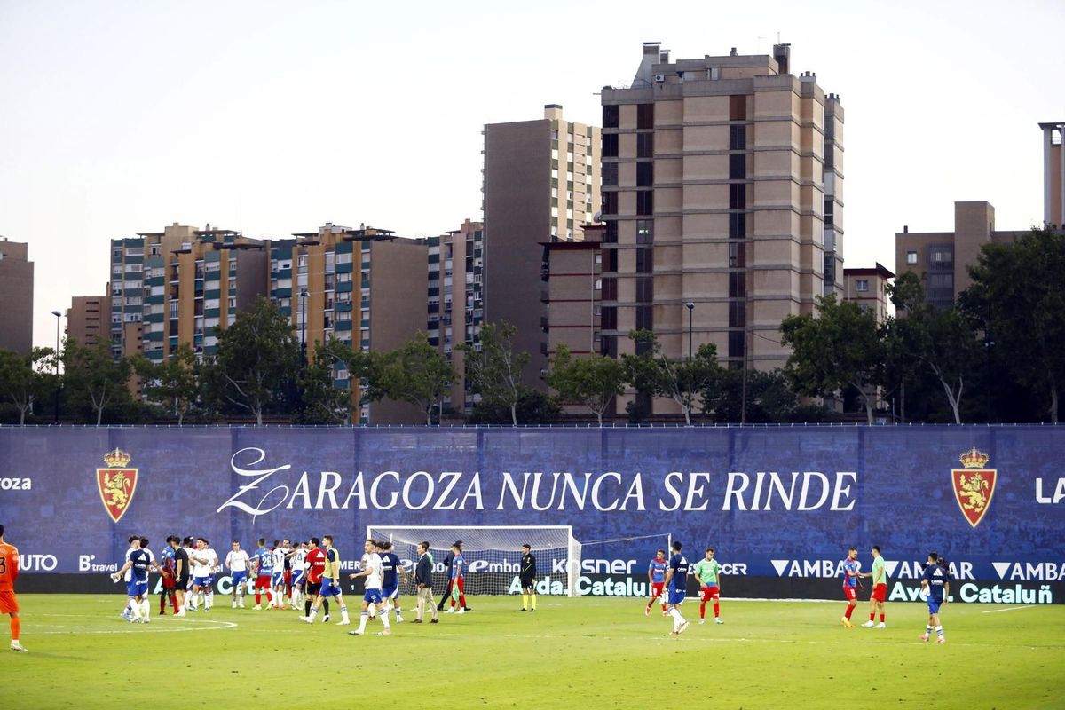 Los jugadores del Real Zaragoza celebran su triunfo ante el Elche, con la lona cubriendo el desaparecido Gol Sur de fondo.