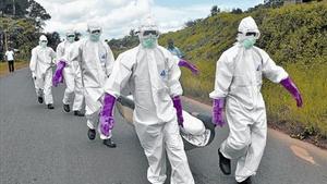 Personal protegit amb vestits especials retira el cos d’un mort per Ebola a Monròvia (Libèria), dissabte.