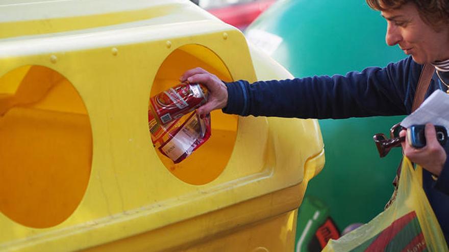 Una vecina recicla unas latas.