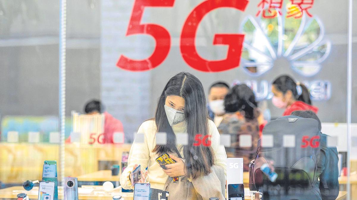 Una mujer examina teléfonos en una tienda de Huawei