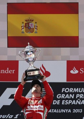 Ferrari Formula One driver Fernando Alonso of Spain holds up his trophy on the podium after winning the Spanish F1 Grand Prix at the Circuit de Catalunya in Montmelo