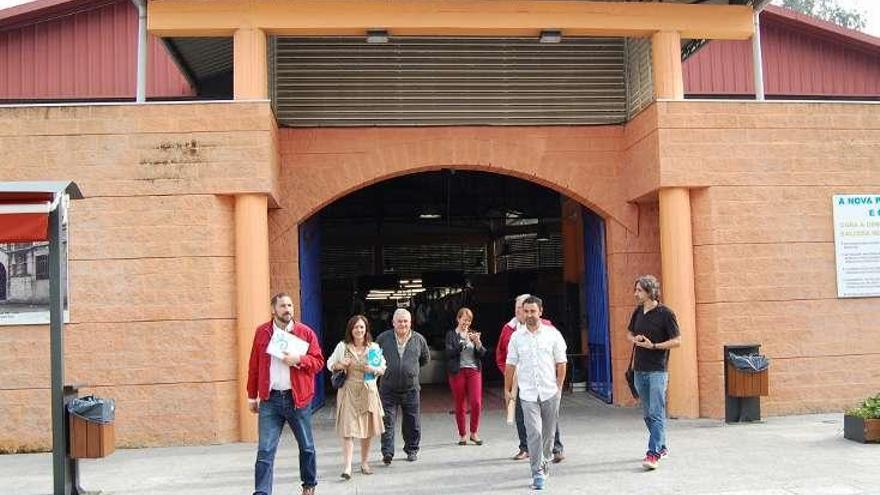 El alcalde de Salceda junto a la edil responsable salen del Mercado en compañía de Carlos Álvarez y otras personas. // D.P.
